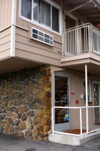 a building with a balcony and a stone wall at San Luis Inn and Suites in San Luis Obispo