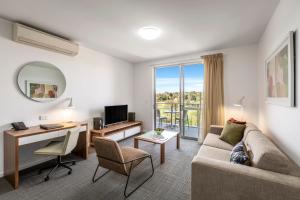 a living room with a couch and a desk at Quest Toowoomba in Toowoomba