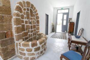 un soggiorno con parete in pietra e sedia di Mascot Boutique Hotel a Città di Rodi