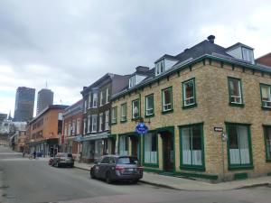 a brick building on a city street with cars parked at EKONO HOSTEL LA BELLE PLANETE BACKPACKERS Downtown Quebec City in Quebec City