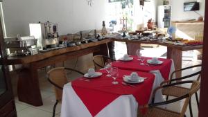 una cocina con una mesa con mantel rojo y blanco en Pousada Maria Bonita, en Arraial d'Ajuda