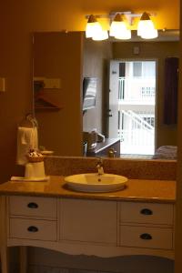 a bathroom with a sink and a large mirror at San Luis Inn and Suites in San Luis Obispo