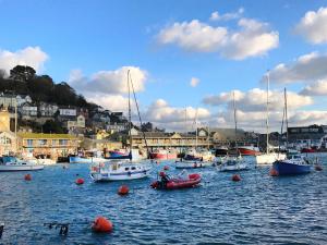 a group of boats in a harbor with houses at Jolly Sailor Inn - THE OLDEST PUB IN LOOE - Family run and full of charm and character in Looe