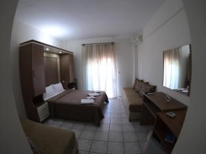 a small hotel room with a bed and a couch at Kopsis Beach Hotel in Pefkochori