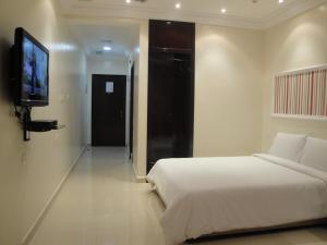 a bedroom with a bed and a flat screen tv at Marina Royal Hotel Suites in Kuwait