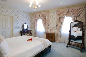a bedroom with a bed and a mirror and curtains at The Residence at Barossa Chateau in Lyndoch