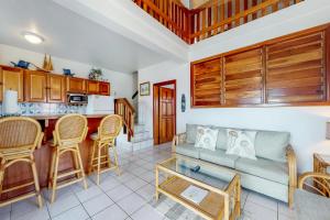 a living room with a couch and a kitchen at Palm @ Caribe Island in San Pedro