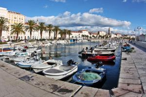 a group of boats docked in a canal with palm trees at Apartment Papalic Palace in Split