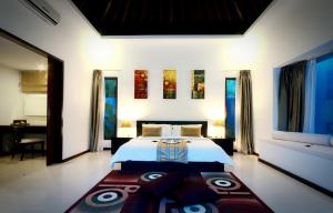 a bedroom with a large bed and a large rug at Kebun Villas & Resort in Senggigi