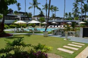 a pool with chairs and umbrellas in a resort at Aligio Beachfront Paradise in Las Terrenas