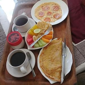 a table with two plates of food and two cups of coffee at Padangbai Beach inn in Padangbai