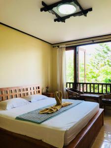 a bedroom with a bed and a large window at Padangbai Beach inn in Padangbai