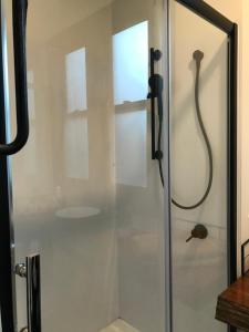 La salle de bains est pourvue d'une douche et d'une porte en verre. dans l'établissement Studio9, à Whangarei