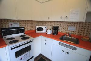 a kitchen with a stove and a sink at Sunset Motel in Port Alberni