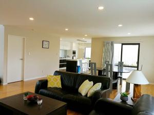 a living room with a couch and a table at Stunning Stay In Glen Eden Auckland in Auckland