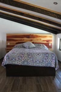 um quarto com uma cama grande e uma cabeceira em madeira em Loft Don Silver em Zacatlán