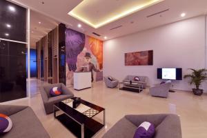 a living room with couches and a flat screen tv at FOX Hotel Pekanbaru in Pekanbaru