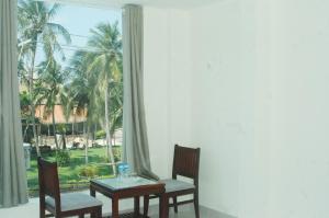 a dining room with a table and chairs and a window at Ha Anh Hotel - Mui Ne in Mui Ne