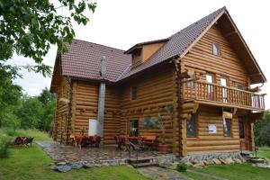 a log cabin with a patio and a deck at Valea Vistisoarei in Vistisoara