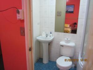 a bathroom with a toilet and a sink at Hostal El Mirador in Punta Arenas