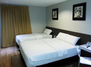 a hotel room with two beds and a desk at Alor Boutique Hotel Sdn Bhd in Kuala Lumpur