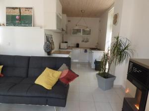 a living room with a couch and a kitchen at La Maison du Palus in Plouha