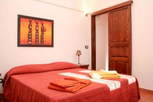 una camera da letto con un letto con una coperta rossa e una porta aperta di Dammuso Favarelle da Caty a Pantelleria