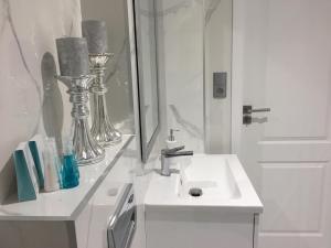 bagno bianco con lavandino e specchio di Mg Apartamenty - Apartament 51 a Oświęcim