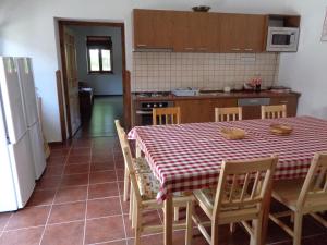 a kitchen with a table and chairs and a refrigerator at Gyöngyszemvendégház in Sátoraljaújhely +7 photos