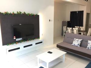 sala de estar con TV grande en la pared en Cameron Quintet Apartment @ Cameron Jaya en Cameron Highlands