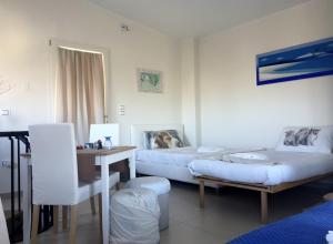 a room with two beds and a table and a desk at La Casetta in Tavullia