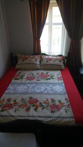 a bed with a blanket on it with a window at Guest House Strumena in Elena