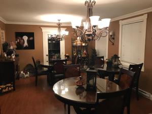 a dining room with tables and chairs and a chandelier at Castle Landing in Placentia