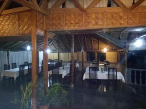 a dining room with tables and chairs in a building at Hotel Pison in Rantepao