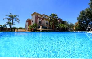 una gran piscina frente a una casa en apartamento campo de golf Isla Canela en Isla Canela