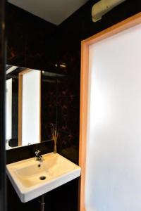 y baño con lavabo blanco y espejo. en Love Box Resort en Samut Prakan