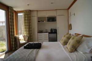 a bedroom with a large white bed and a kitchen at Oriental Bay At Its Best in Wellington