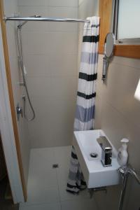 y baño con lavabo y ducha. en Oriental Bay At Its Best en Wellington