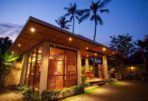a small house with a lit up facade at night at Ellora Villa in Sanur