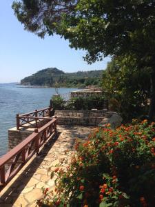 a wooden bridge over a body of water with flowers at Villa Nelly by the sea in Néa Koróni