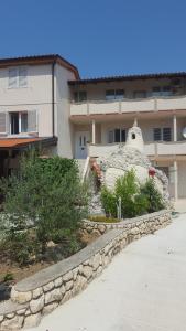 a large rock statue in front of a building at Apartments Ribica in Rab