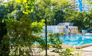 a playground in a park with a swimming pool at Апартамент Бриз in Burgas