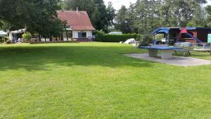a large yard with a picnic table and a playground at Campingplatz Blauer See in Lünne