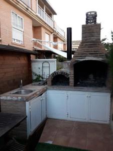 an outdoor kitchen with a brick oven and a sink at casudha de juanda in Grao de Castellón