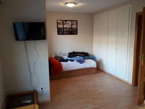 a bedroom with a bed and a flat screen tv at casudha de juanda in Grao de Castellón