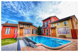 una piscina di fronte a due edifici di Villa Di Montagna at Khaoyai a Pak Chong
