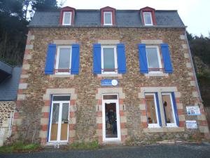 une vieille maison en briques avec des volets bleus. dans l'établissement La Maison du Palus, à Plouha