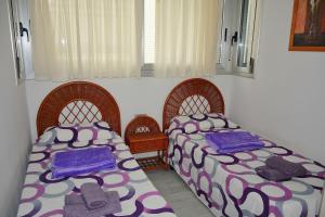 two beds in a room with purple and purple blankets at Princesa Denia in Denia +11 photos