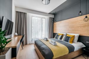 a bedroom with a large bed and a desk at Vistula Apartments by LoftAffair in Krakow