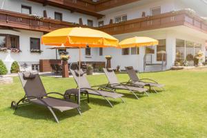 grupa krzeseł i parasoli na dziedzińcu w obiekcie Hotel Schönegg w mieście Seefeld in Tirol